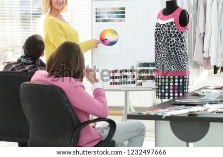 woman pointing at swatch color palette while discussing what color to choose with colleague