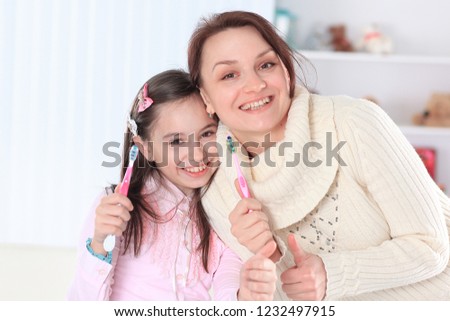 mom and daughter brushing their teeth.photo with copy space