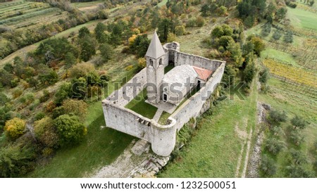 Old Romanesque church of Holly Trinity within defensive fortress walls in Karst village of Hrastovlje in Istria, Slovenia Royalty-Free Stock Photo #1232500051