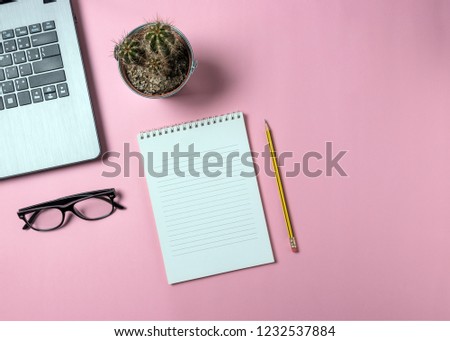 Creative flat lay photo of workspace desk with laptop, eyeglasses, cactus and notebook with copy space background. Minimal concept art.