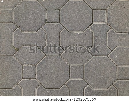 Stone pavement with grass texture. Top view on cobblestoned pavement background. Abstract background of old cobblestone pavement street