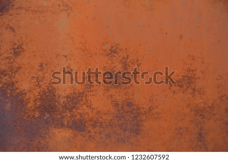 Reddish-orange paint that's faded on rusty metal. 