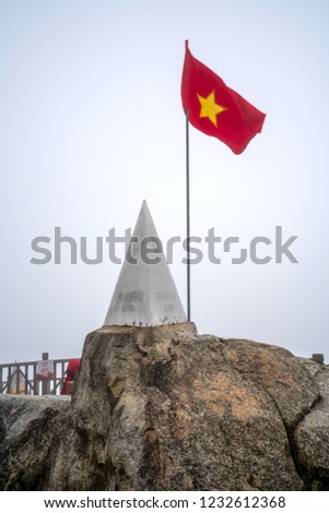 Vietnamese flags and monument at summit of Fansipan - the highest mountain in Indochina located in Sapa Hoang Lien Son mountain range, Lao Cai Province, Vietnam
