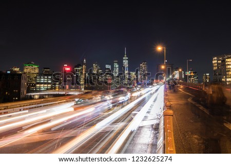The New York City skyline as seen from the Brooklyn Bridge, as traffic crosses the bridge. 