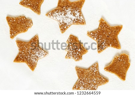 Christmas Gingerbread Cookies, Stars, bells, Christmas tree from sweet dough on white paper for baking