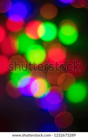 Abstract multi-colored bokeh on a black background. Defocused abstract lights christmas background. Selective focus. Blur