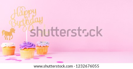 Creative pastel fantasy holiday card with cupcake, happy birthday topper and unicorn. Baby shower, birthday, celebration concept. Horizontal, wide screen banner format