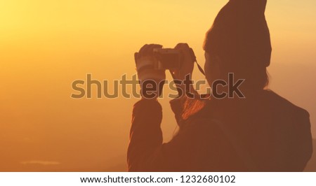 Young Girl Taking Photos Of Sunset Landscape With mirrorless camera