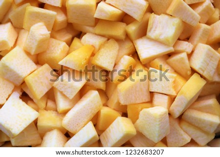 uncooked cube size pieces of chopped winter squash, orange in color. Perfect for background pictures for pumpkin pie and other Fall recipes. 