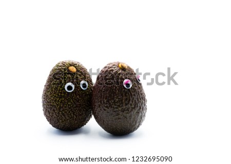 Romantic avocados couple with googly eyes as man and woman, funny food concept for creative projects.
