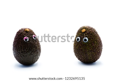 Romantic avocados couple with googly eyes as man and woman, funny food concept for creative projects.