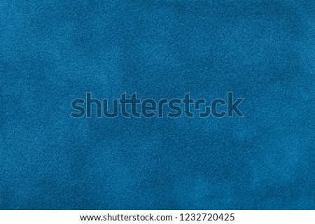 Navy blue matte background of suede fabric, closeup. Velvet texture of seamless turquoise leather. Felt material macro.