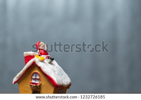 Merry Christmas and happy holidays! Cute Santa Claus sitting on the roof, Christmas legend concept.