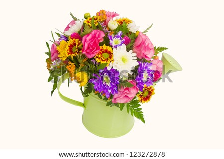 Colorful bunch of spring flowers in watering pot isolated over white background