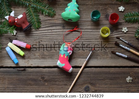 Painting Christmas toys from porcelain for decorations. Making clay toy with your own hands. Children's DIY concept. Handmade crafts on holiday. Master class of art