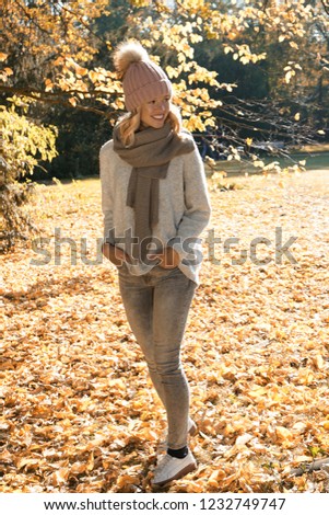 Beautiful blonde girl walking through an autumn landscape