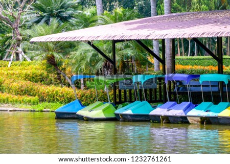 Many colorful paddle boat parking the dock. Thai language appeared in this picture means "danger"