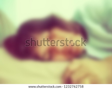 Depressed woman laying on the bed in bedroom for stress concept, blurred photo.