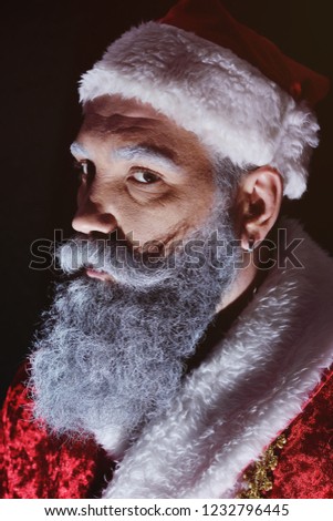 evil Santa Claus  angrily looks at the camera on a dark background