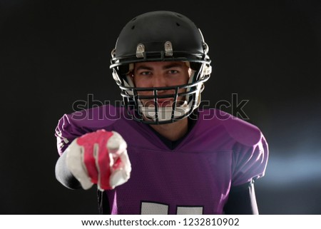 American football player wearing uniform on dark background