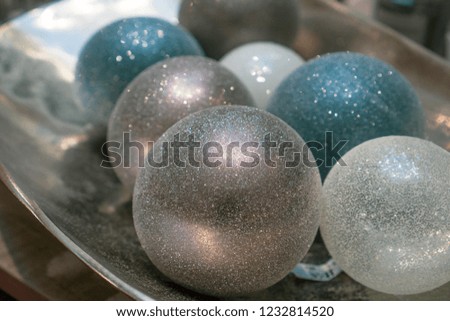 Christmas sparkling balls on a silver plate. Abstract festive background for design. Winter holiday deco, Happy New Year, Merry Xmas. Closeup.  