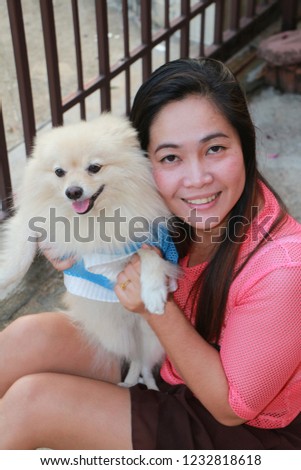 Asian woman holding happy dog with smiliing 