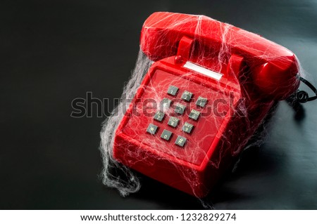 Obsolete technology and abandoned telephone concept with a vintage phone covered in spider webs isolated on black background with copy space Royalty-Free Stock Photo #1232829274