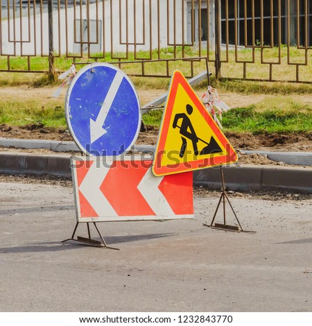 Work in progress. Roadworks, road signs. Men at work. Some signs signage for work in progress on urban street. left arrow.