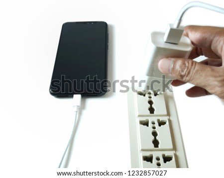 Hand holding a mobile charger and connect with mobile isolated on white background