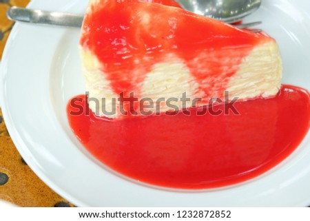 Sweet of cheese cake on white dish, delicious of cheese cake and strawberry jam on topping 