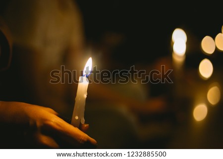 soft focus of people lighting candle vigil in darkness seeking hope, worship, prayer