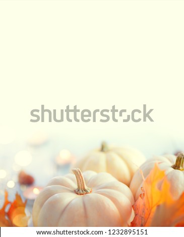 Thanksgiving Day Dinner, Served holiday table decorated with pumpkins, colorful autumn leaves and candles. Thanksgiving background, beautiful table setting. Vertical image