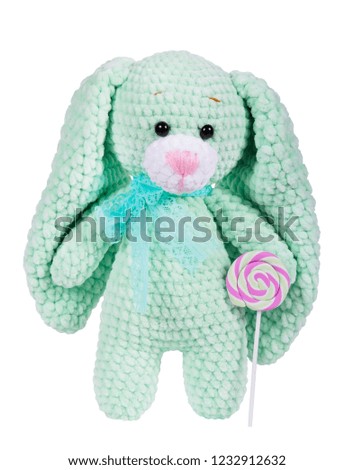 Soft toy knitted bunny and lollipop. Isolated on white. Toy bunny. Plush crocheted bunny. Cut out.