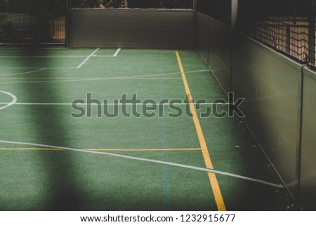football small playground empty place and synthetic surface behind black unfocused fence frame 