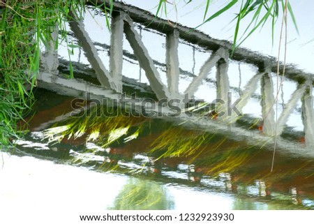 Picturesque reflection of a bridge in vibrating water surface.