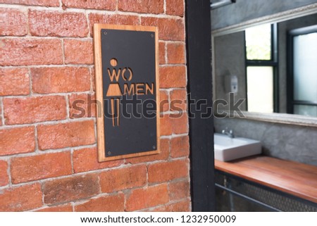 public restroom or toilet with women signs on brick wall decorate