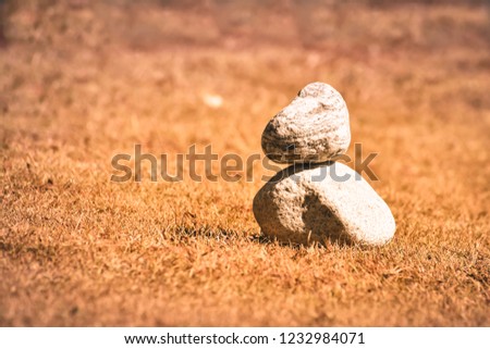Stack of rock pebble on sea beach in sunlight. Ground level view. Stone Balance tranquil  conceptual composition. Copy space for text.