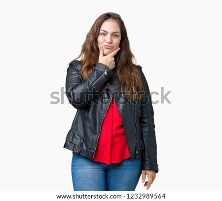 Beautiful plus size young woman wearing a fashion leather jacket over isolated background looking confident at the camera with smile with crossed arms and hand raised on chin. Thinking positive.