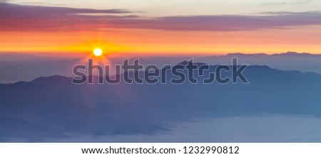 Mountain range in morning sunrise with sun flare.Sea of fog foreground .Panorama photo form summit of Doi Luang Chiang dao, Chiangmai, Thailand.
