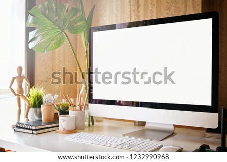 Mockup computer with white screen on office table. Workspace and blank screen computer.