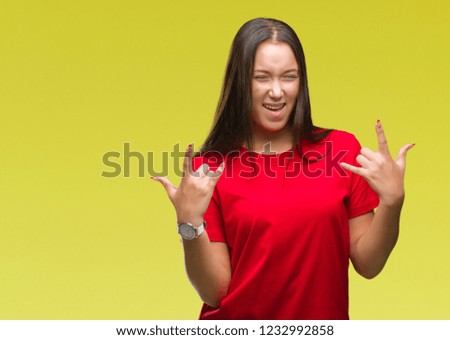 Young beautiful caucasian woman over isolated background shouting with crazy expression doing rock symbol with hands up. Music star. Heavy concept.