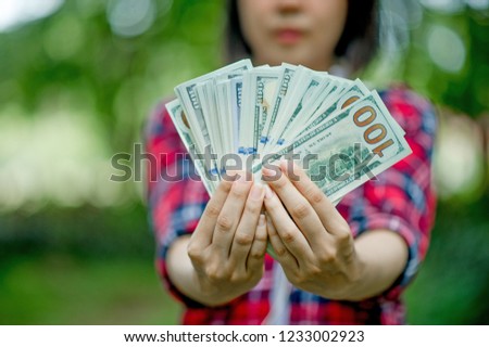 Portrait of a happy young girl with a dollar on hand. And there is a copy space.