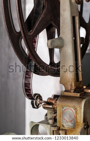detail of an old and rusty cinema projector with film roll