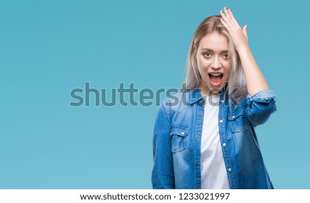 Young blonde woman over isolated background surprised with hand on head for mistake, remember error. Forgot, bad memory concept.