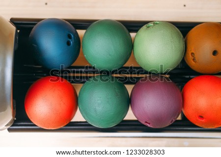 Rows of color bowling balls in feeder, top view