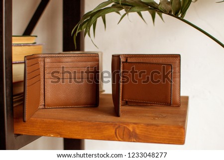 two mens leather wallet on a wooden shelf, leather wallet (horizontally, toned)
