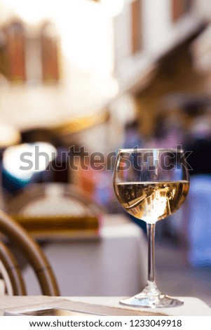 Glass of chilled white wine on Garda streets background