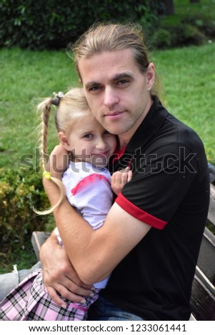 father hugs little daughter
