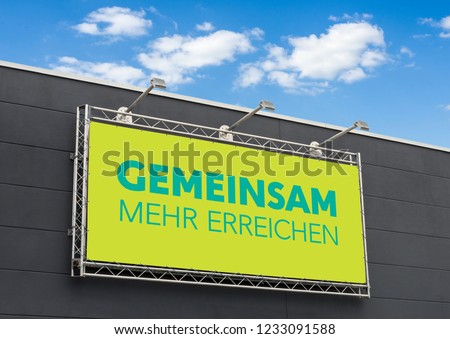 The german words Gemeinsam mehr erreichen (Together we can achieve more) written on a billboard
