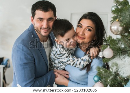 Happy Family Decorating Christmas Tree together. Father, Mother And Son.